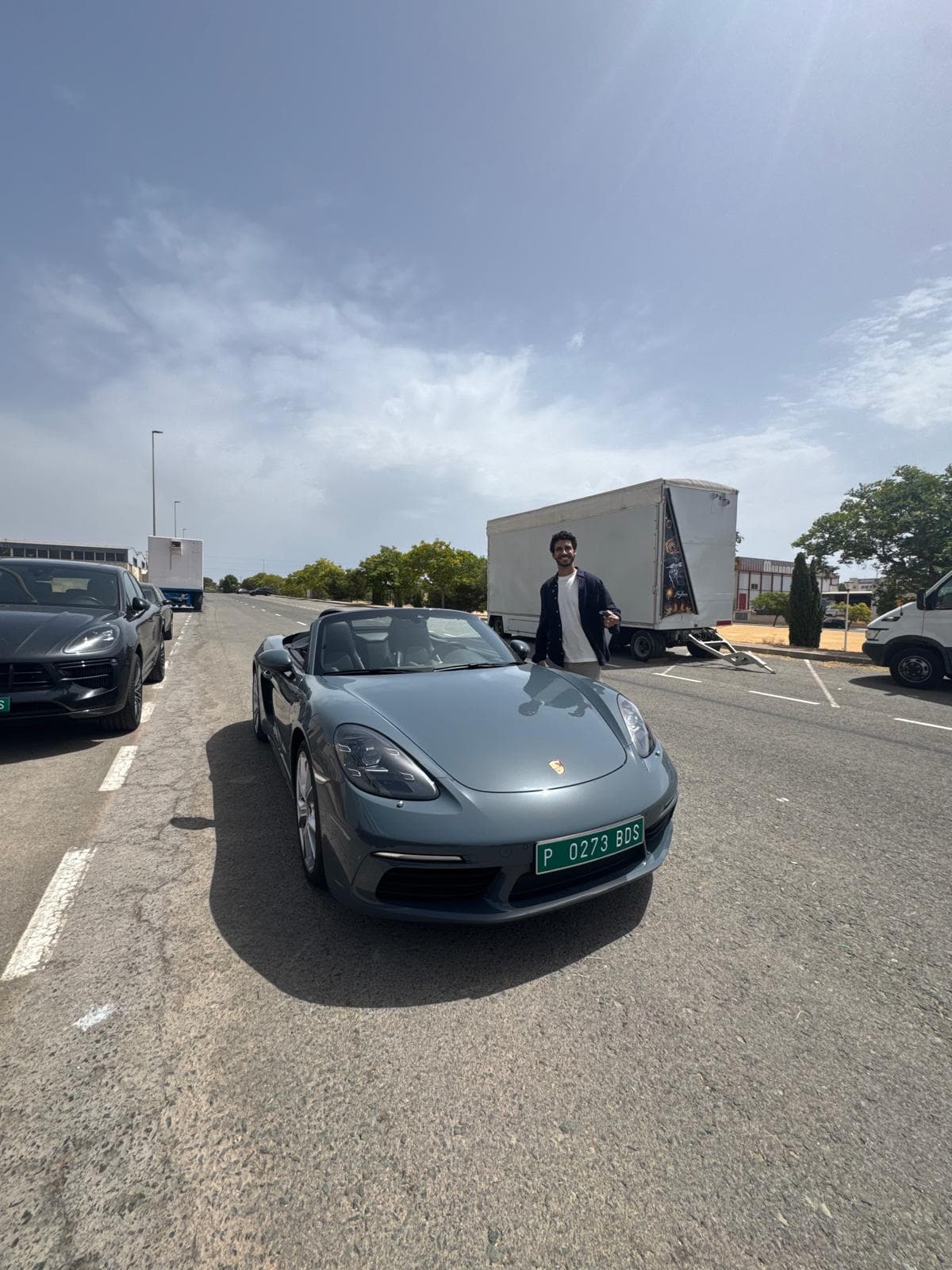 Persona junto a un Porsche descapotable durante una entrega documentada