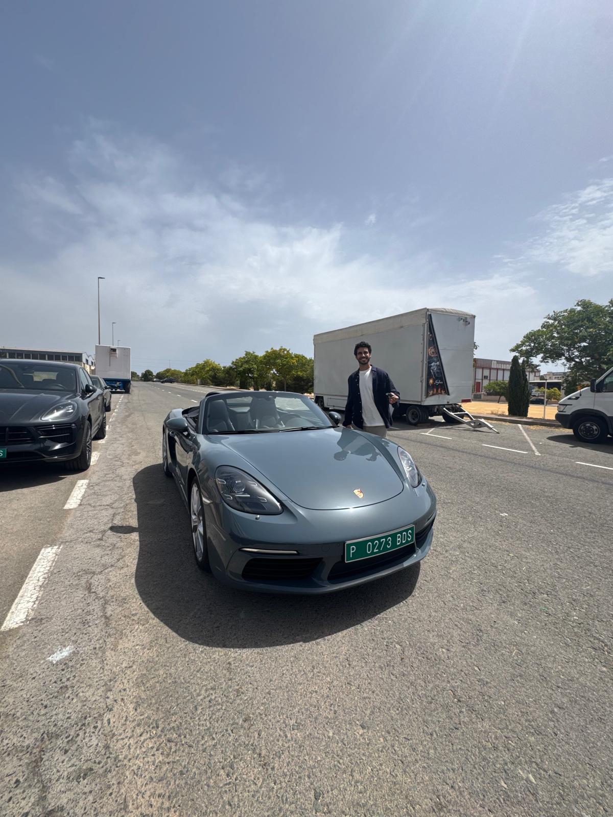 Persona junto a un Porsche descapotable durante una entrega documentada